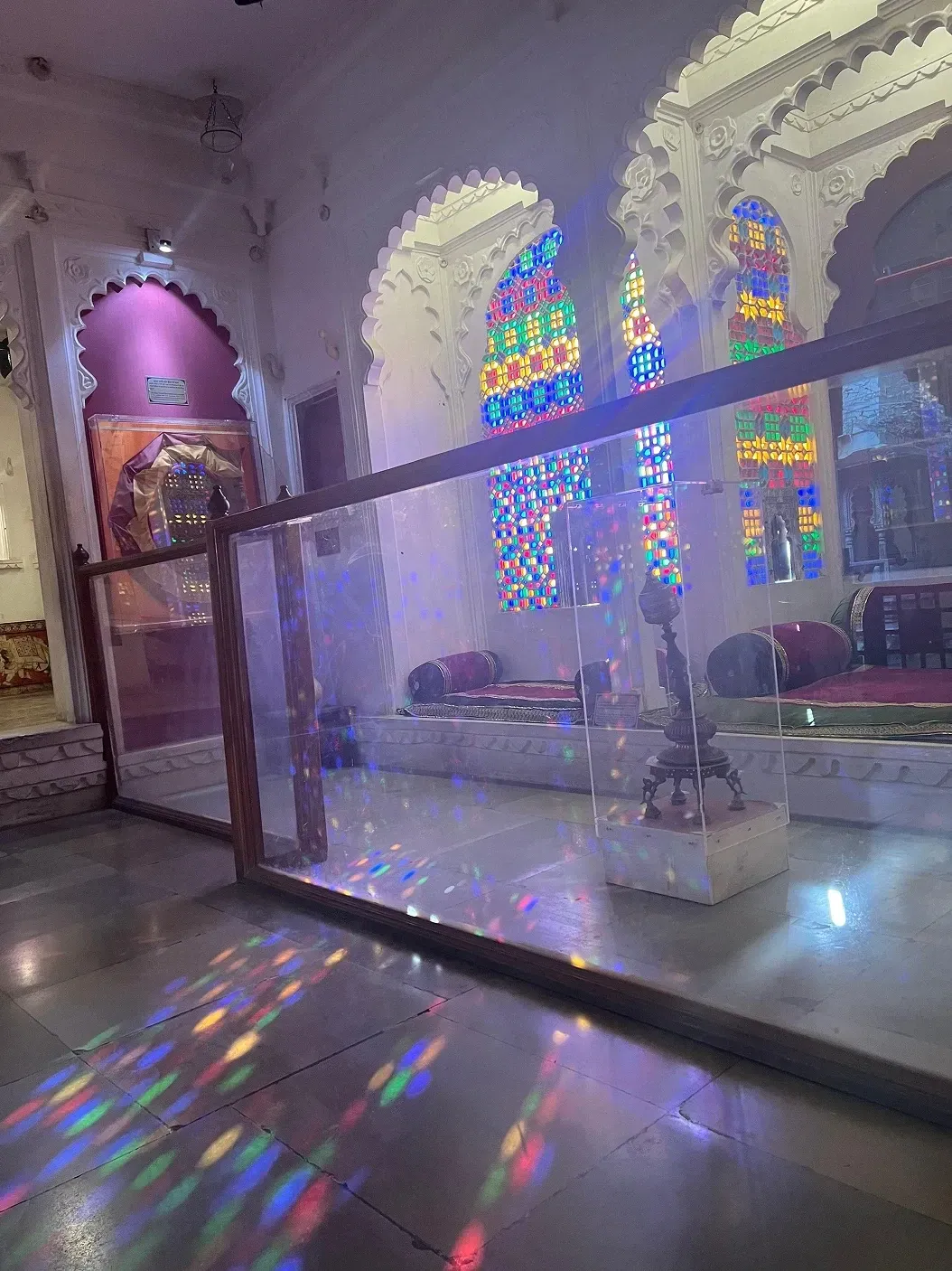 Palace hall with stained glass windows casting coloured light on the floor