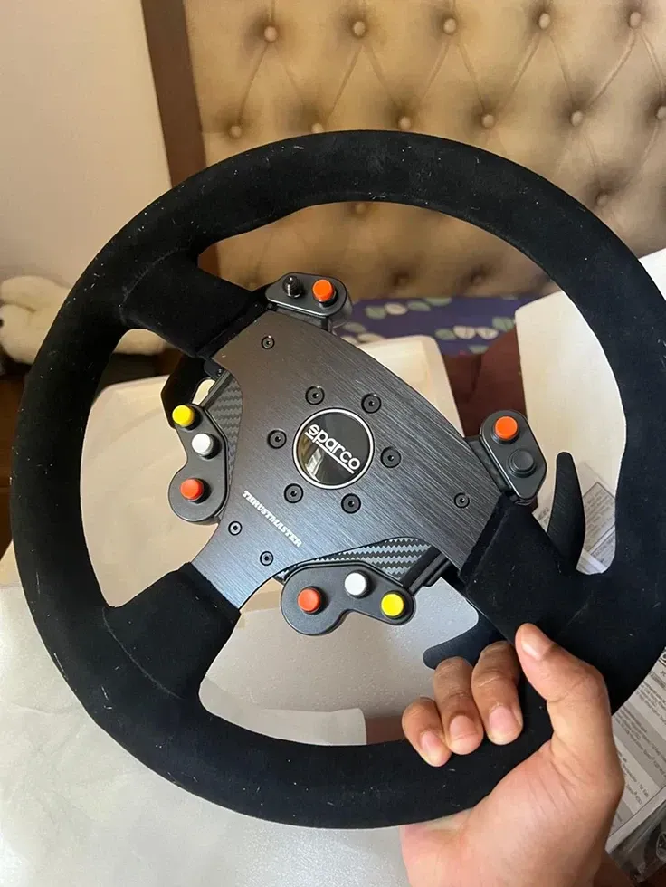Hand holding a sim racing steering wheel