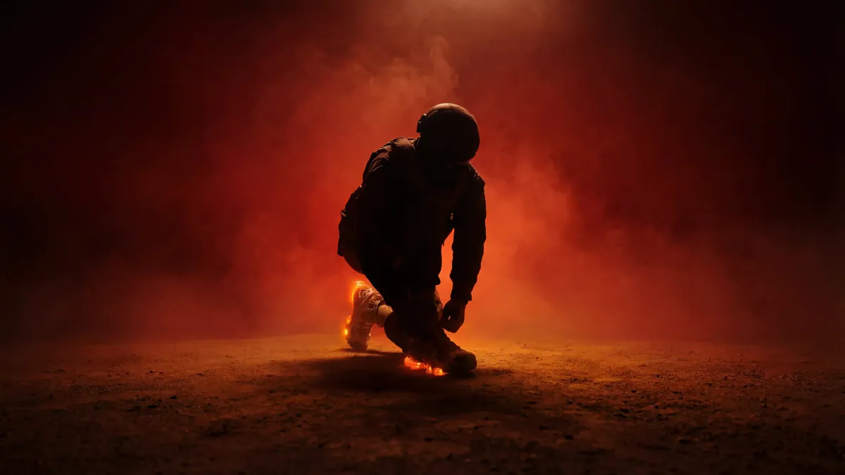 Silhouetted runner lacing a glowing sneaker in red haze
