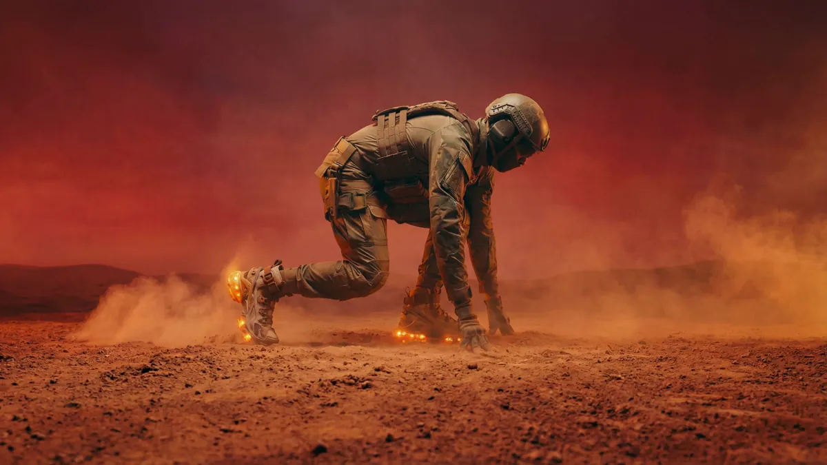 Runner in a sprint start crouch on a dusty plain