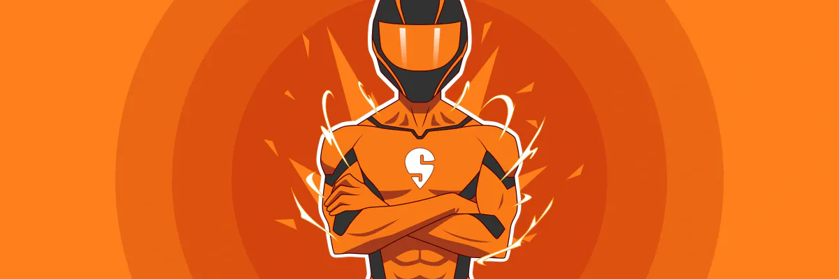 Rider mascot in an orange helmet and suit with arms crossed on an orange background