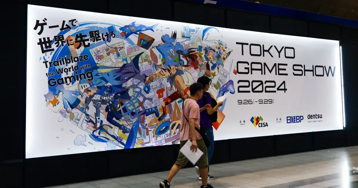 Visitors walking past a large Tokyo Game Show 2024 banner