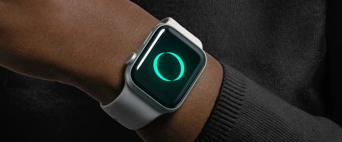 Smartwatch on a wrist showing the glowing turquoise ZERO ring